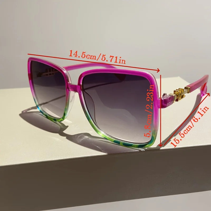 Pink retro sunglasses with a gradient lens and gold accents shown on a white surface.