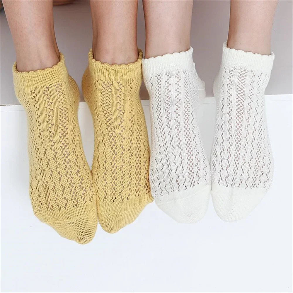 A pair of yellow and white breathable mesh lace tube socks for women