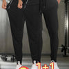 A pair of black breathable men's casual jogger pants being worn by a model in a gym setting.
