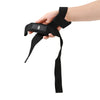 Une main porte un bandage de poignet noir robuste pour l'entraînement de force.