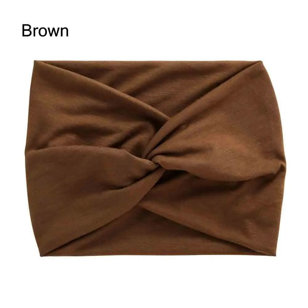 A brown fabric headband is shown folded in a cross-knotted style.