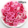 Haufen von 300 rosa und magentafarbenen Nylon-Elasthebändeln für Pferdeschwänze und Zöpfe.