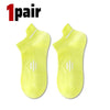 A pair of bright yellow breathable men's running socks shown flat.