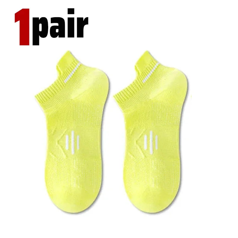 A pair of bright yellow breathable men's running socks shown flat.