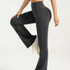 A model wearing high-waisted black bootcut yoga pants and a light blue cropped top.