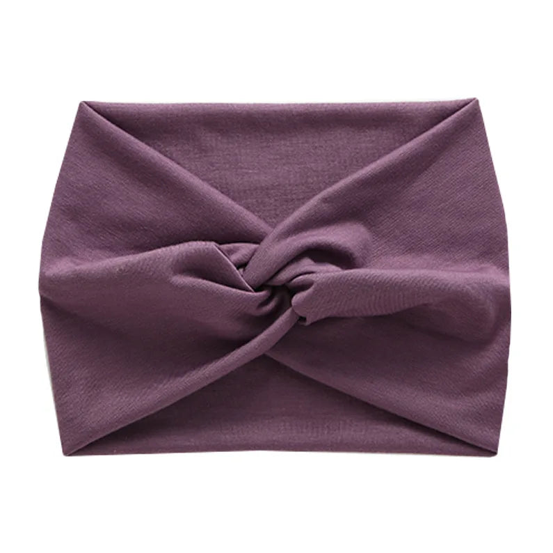 A purple women's elastic sports headband folded and tied in a knot.