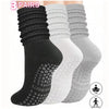 A set of three pairs of black, white, and gray silicone socks for Pilates and yoga
