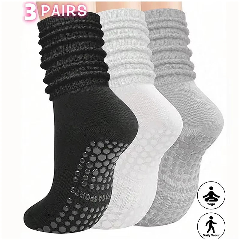A set of three pairs of black, white, and gray silicone socks for Pilates and yoga