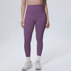 A model is wearing purple high-waisted quick-drying yoga and fitness leggings with white socks and white athletic shoes.