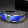 Une paire de lunettes de soleil bleues polarisées avec des montures noires posées sur une surface gris foncé.