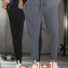 A two-piece set of breathable men's casual jogger pants in gray and black shown on a model.