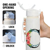 A white insulated straw tumbler with a lock and unlock mechanism is shown being held by a hand.