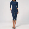A woman wearing a navy blue long-sleeved top and matching leggings set for yoga or fitness.