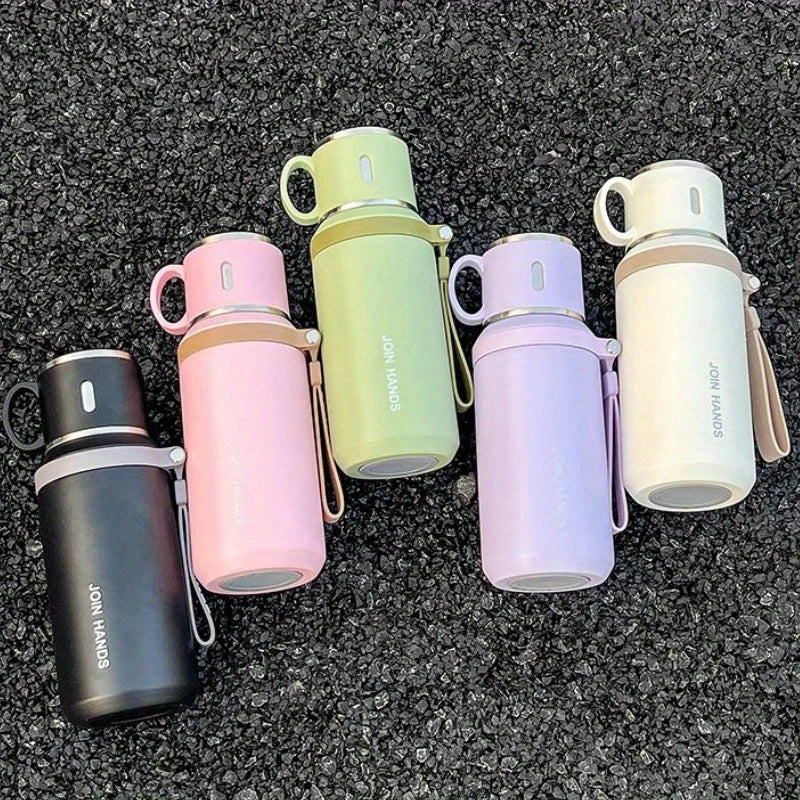 A collection of five colored stainless steel insulated water bottles in shades of pink, green, purple, and cream.