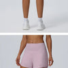 Ein Model trägt dunkelblaue, schnelltrocknende Sportshorts und weiße Socken vor einem hellgrauen Hintergrund.
