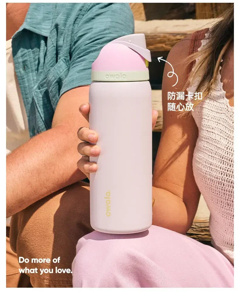 A person holds a pink insulated tumbler with a straw lid, demonstrating its use.