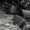 Black thermal fleece touchscreen gloves worn by a person in an outdoor setting.