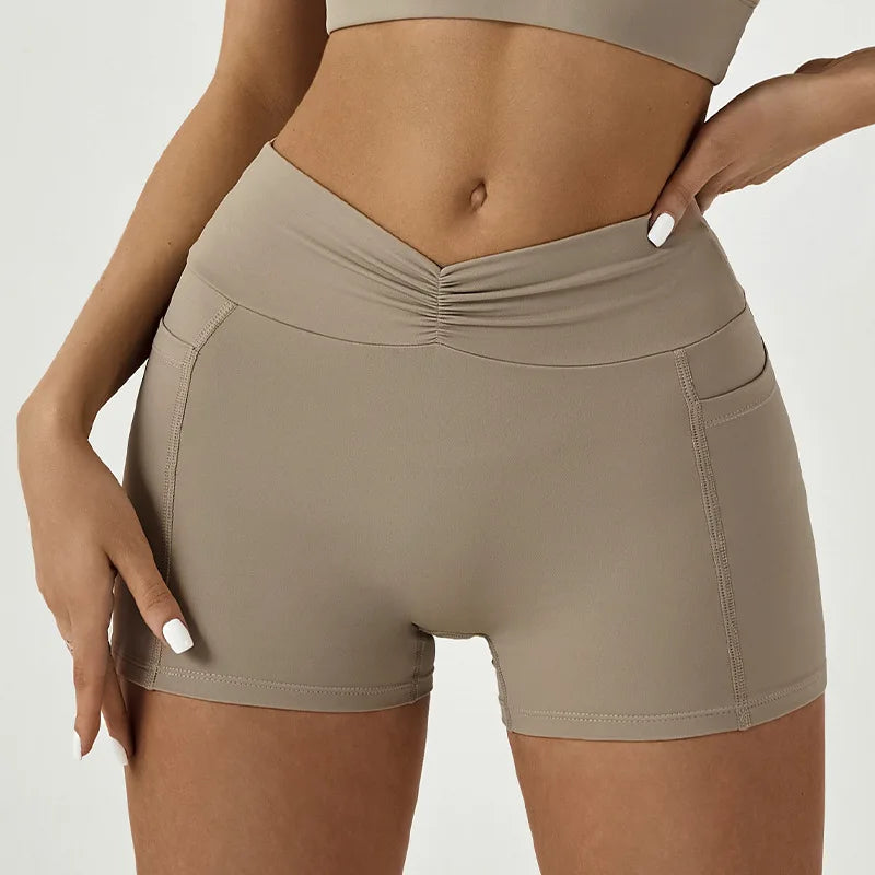 A model wearing high-waisted yoga and fitness leggings in a beige color.