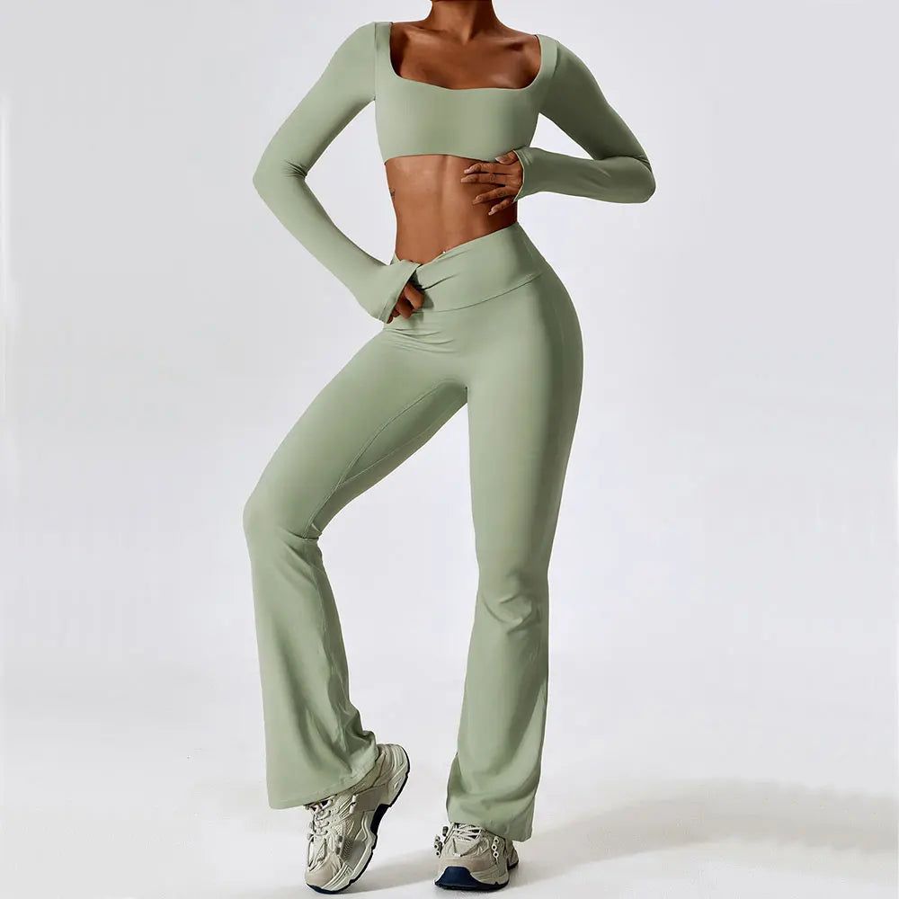 A model wearing a light sage green women's performance tracksuit set top and pants.