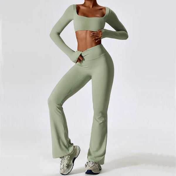 A model wearing a light sage green women's performance tracksuit set top and pants.