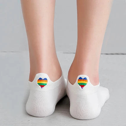 A pair of white ankle socks with a rainbow embroidery on the toe, shown against a light gray background.