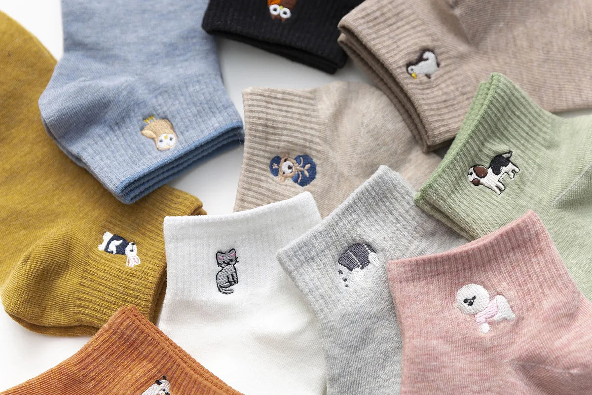 A collection of pastel and earthy colored cotton socks featuring various kawaii embroidered animal designs.