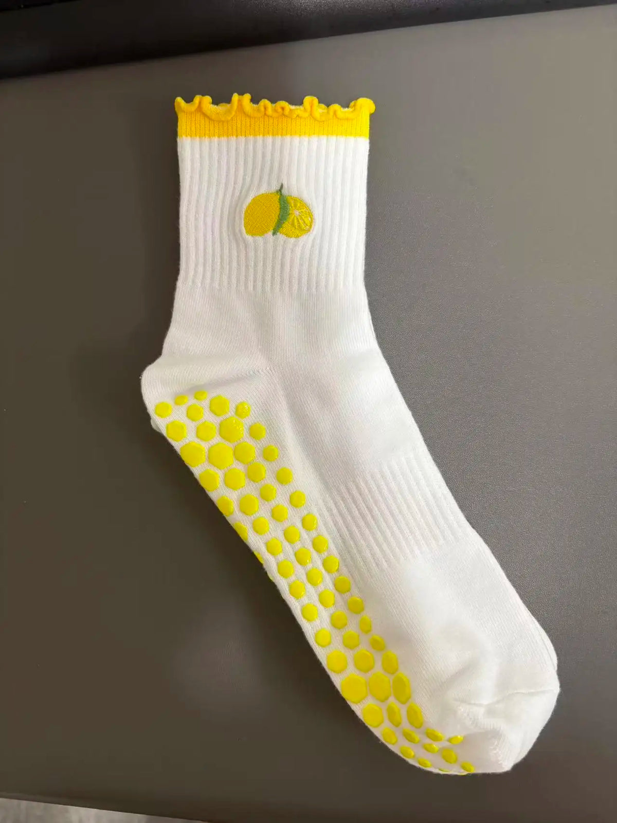 Weiße Strick-Yoga-Socken mit gelbem Zierrand und Zitronengrafikdetail