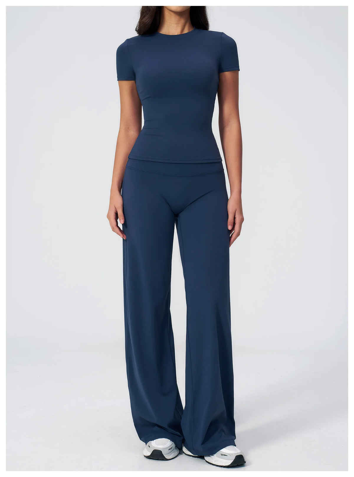 A woman wearing a navy blue high-waist yoga and gym leggings set.