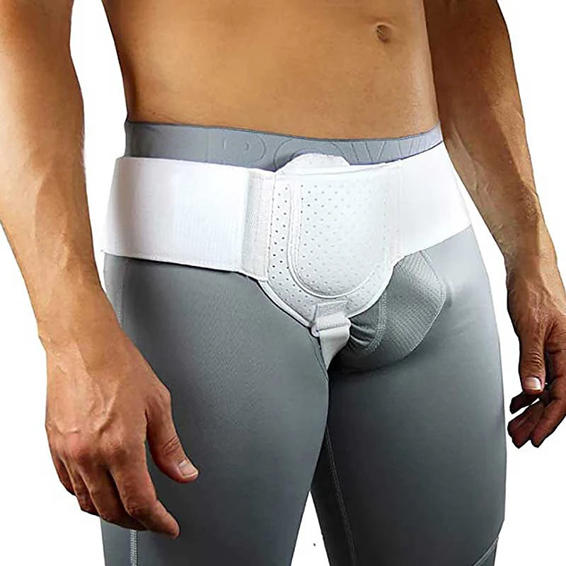 Una persona vistiendo una prenda gris con un arnés de hernia blanco para soporte.