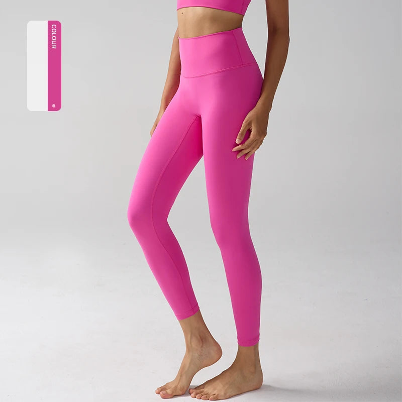 Un mannequin porte des leggings de performance roses vifs à taille haute dans un studio.
