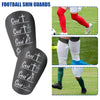 Protectores de espinilla de fútbol negros con varios diseños mostrados en la pierna de una persona.