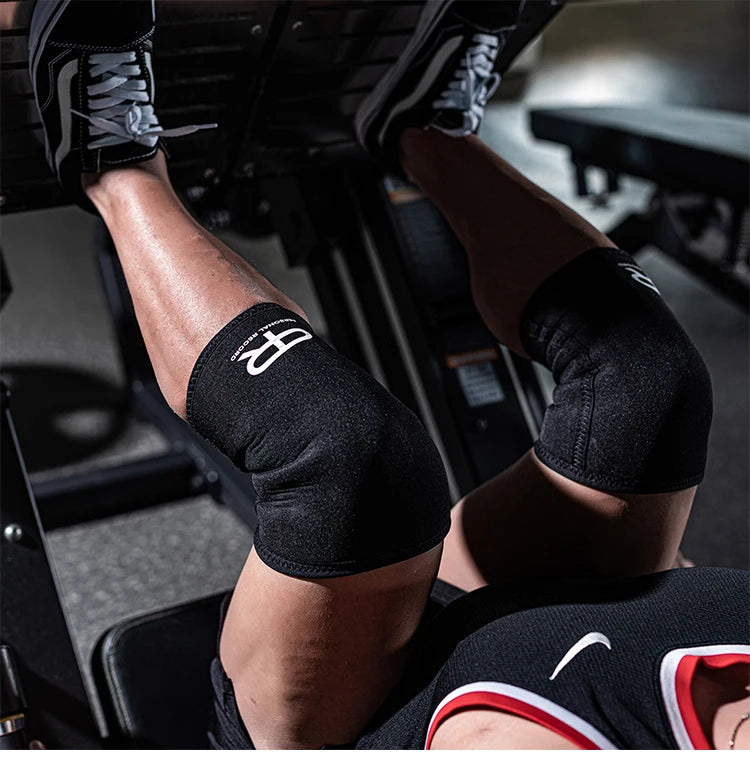 Black neoprene knee pads worn by a person during a lifting or fitness exercise.