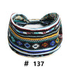 A colorful, striped boho polka dot knotted headband with a bow, featuring black, blue, yellow, and white patterns.