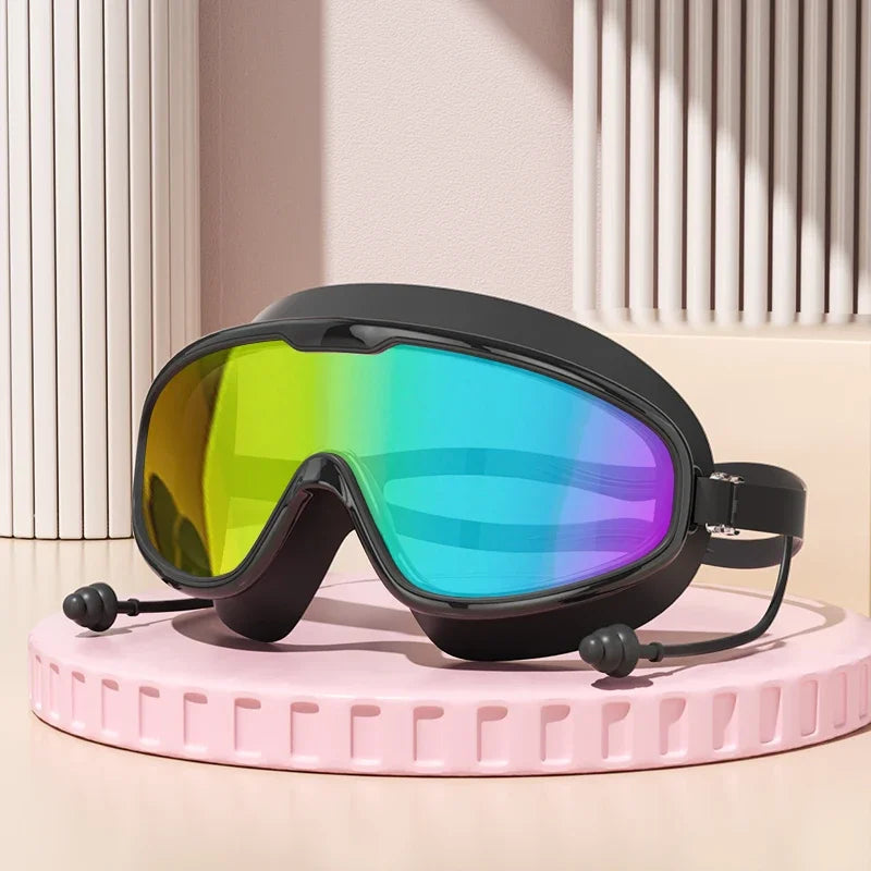 Unos lentes de natación negros antiempañantes con lente arcoíris vibrante sobre una superficie rosa.