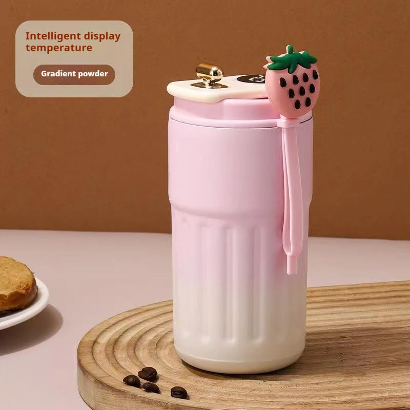 A pink thermo mug with a strawberry lid and an intelligent display showing a gradient powder temperature.