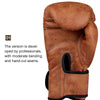 A close-up view of a brown PU leather boxing glove with hand-cut seams and moderate bending.