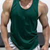 A muscular man wearing a dark green sleeveless tank top and light gray shorts.