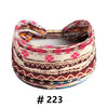 A patterned boho cotton turban headband with pink, orange, and brown geometric designs.