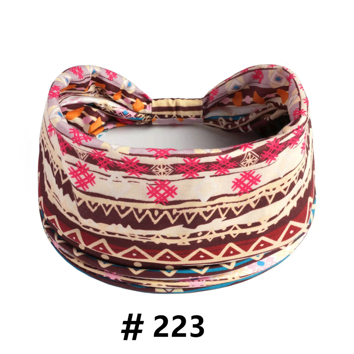 A patterned boho cotton turban headband with pink, orange, and brown geometric designs.
