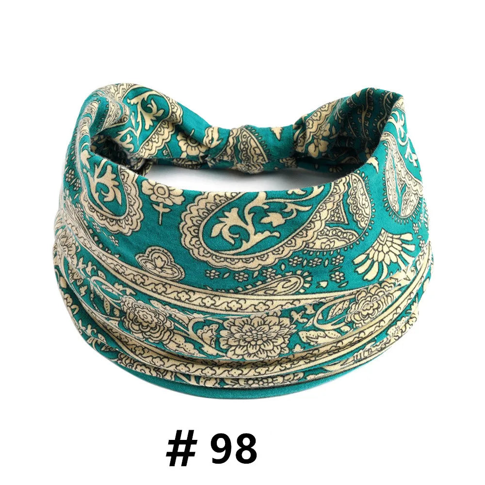 A teal patterned cotton headband with a gathered top, featuring intricate floral and leaf designs.