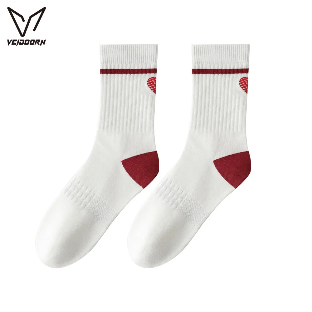 A pair of white crew socks with maroon stripes and heart patterns for athletic activities.