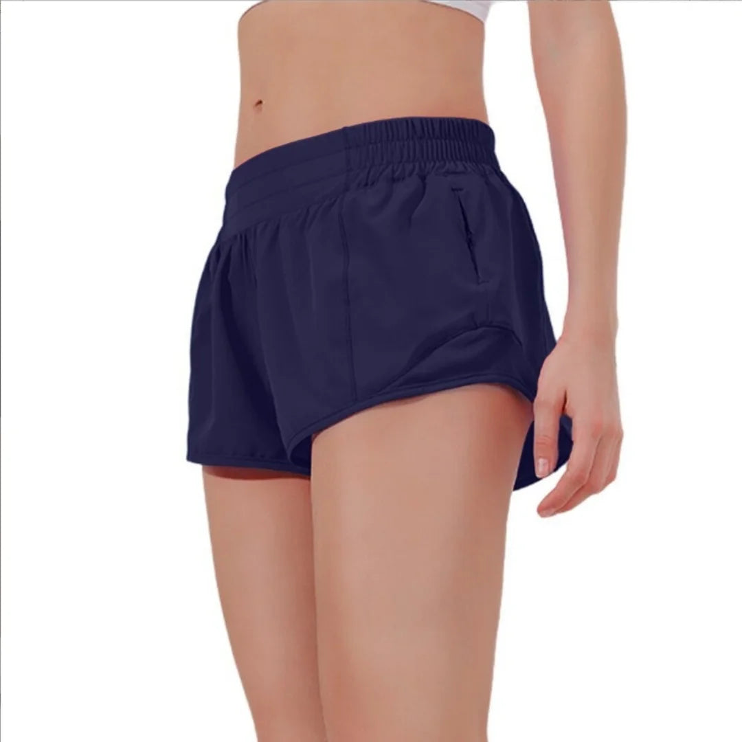 A woman is wearing navy blue high-waisted running shorts.