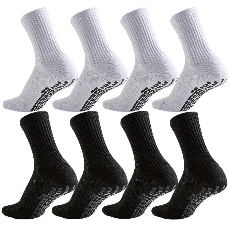A set of white and black athletic grip socks shown from the side.