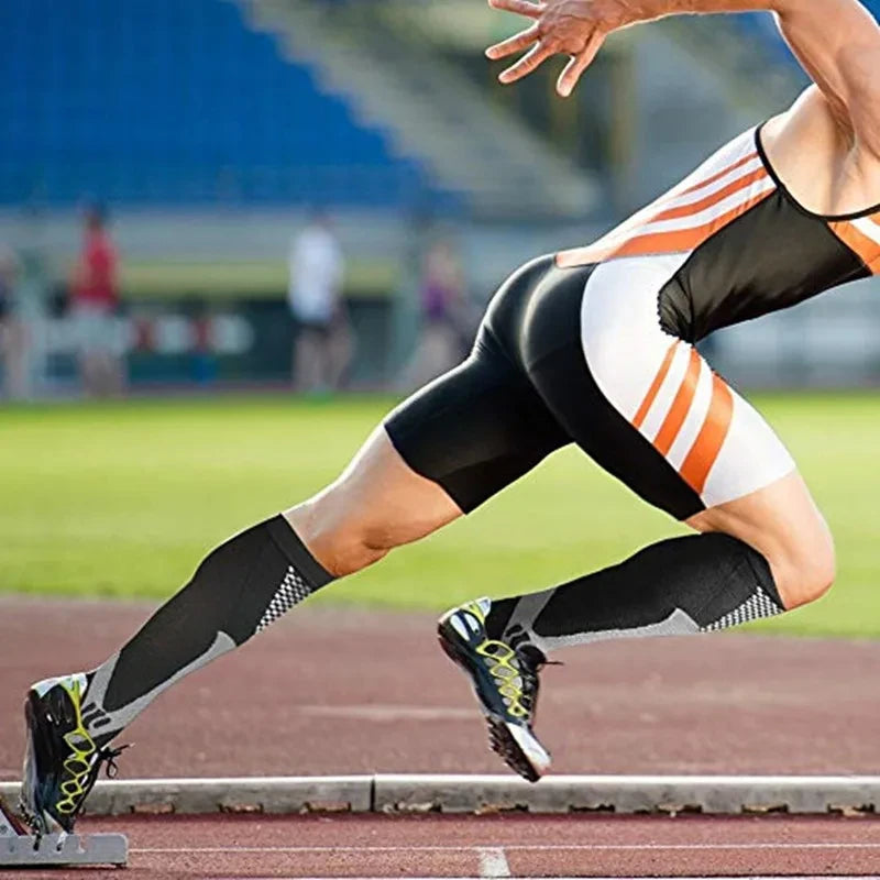A male athlete wearing compression socks while running on a track.