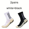 Ein Paar weiß-schwarzer rutschfester Sportsocken von der Seite.