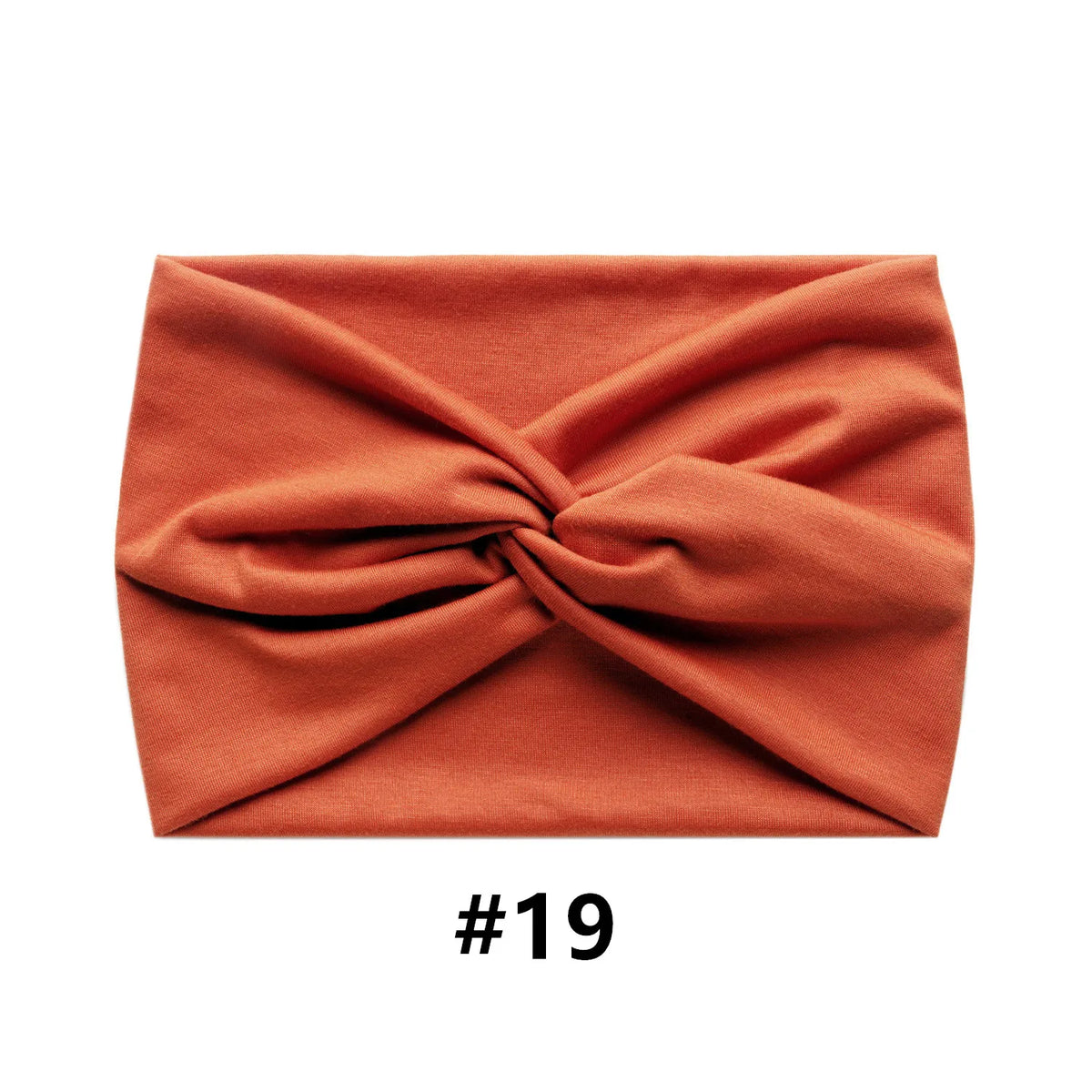 A folded terracotta orange fabric headband with a knotted design.