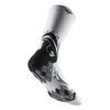 A close-up view of a white athletic sock with a black and gray camouflage pattern.