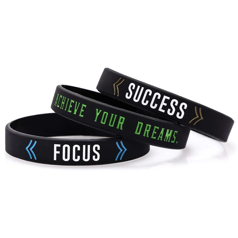 Black silicone wristbands with motivational text Achieve Your Dreams and Focus
