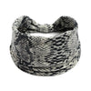 A black and white patterned stretch fabric headband rolled into a coil.