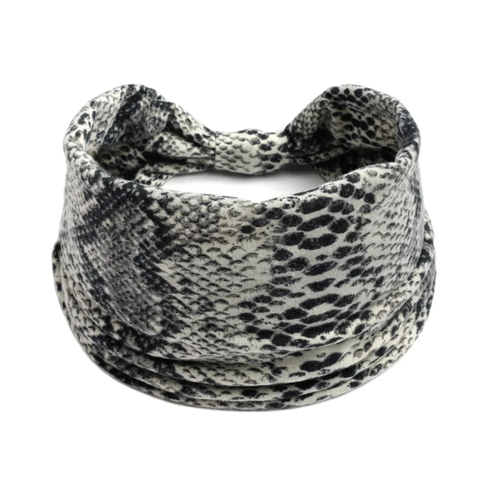 A black and white patterned stretch fabric headband rolled into a coil.